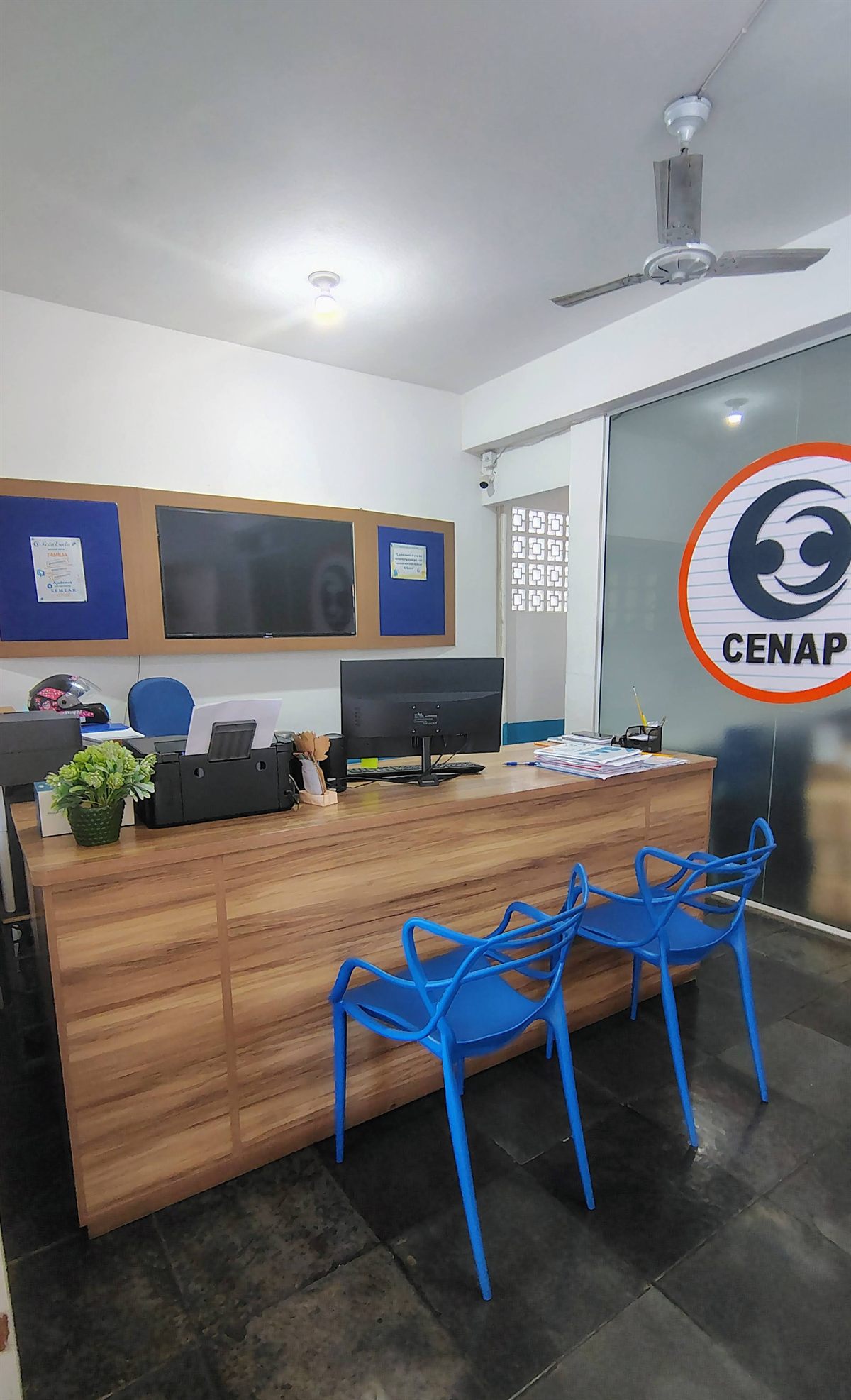 Recepção do CENAP, com a logo da escola na parede de vidro